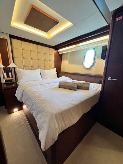 a bed with a white bed spread aboard VIVERE Yacht for Sale