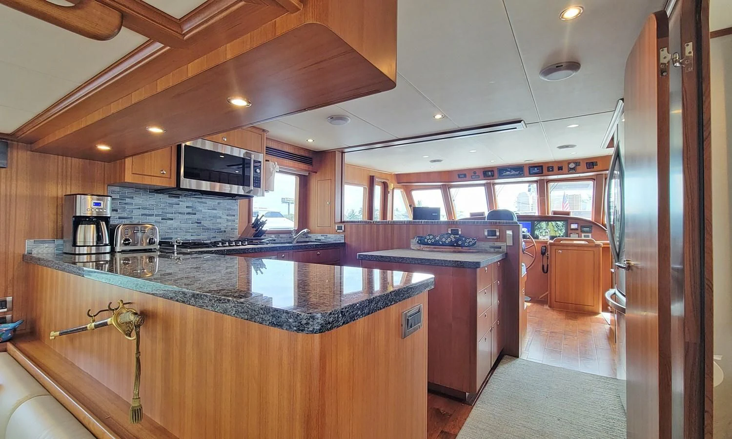 a kitchen with a bar and a large island aboard SUERTUDO Yacht for Sale