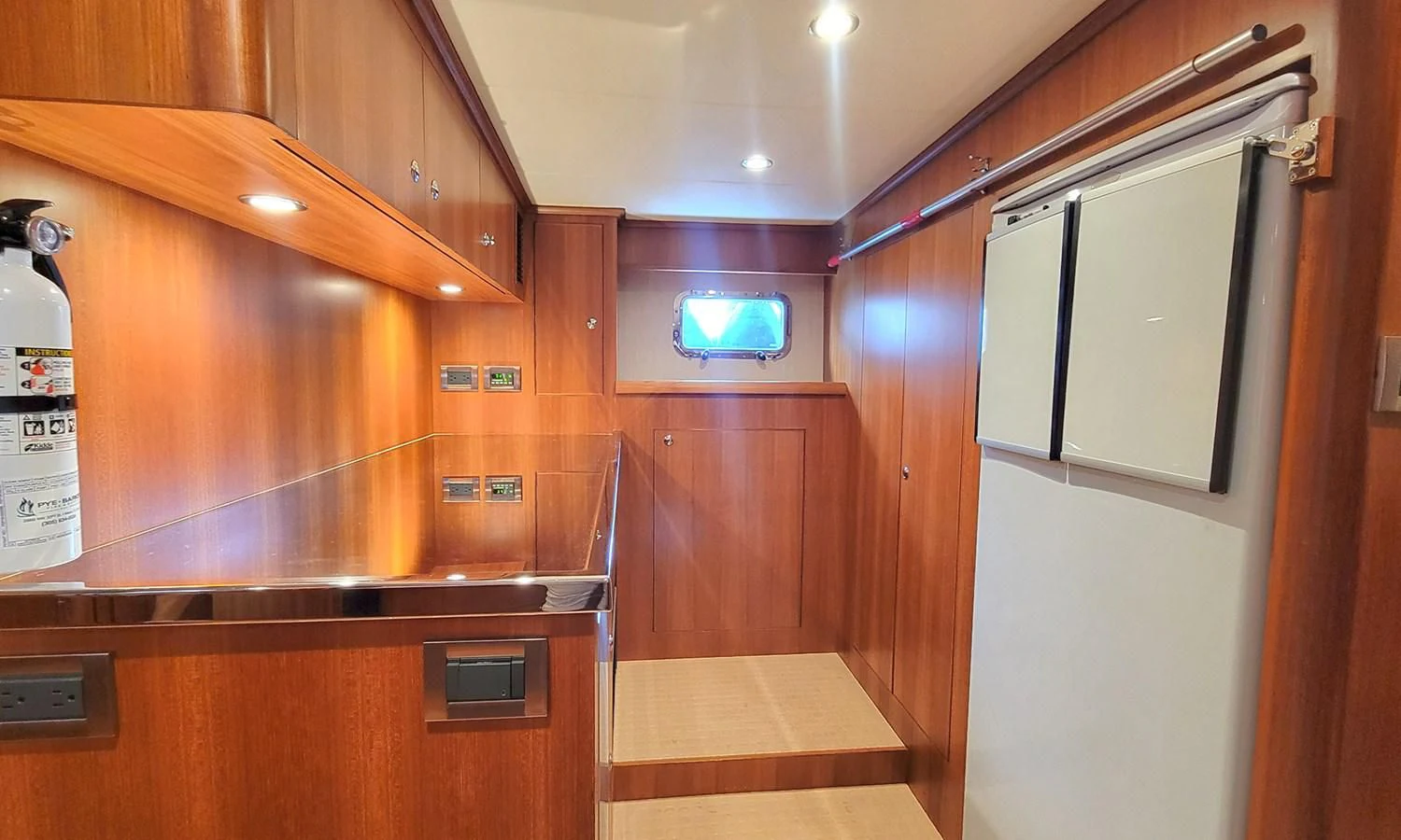 a kitchen with wooden cabinets aboard SUERTUDO Yacht for Sale