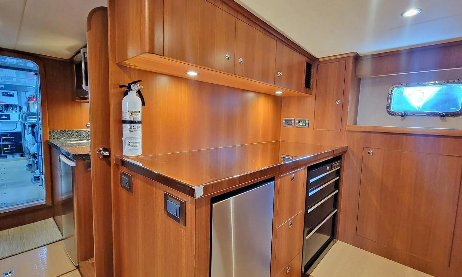 a bottle of liquor on a wooden cabinet in a kitchen aboard SUERTUDO Yacht for Sale