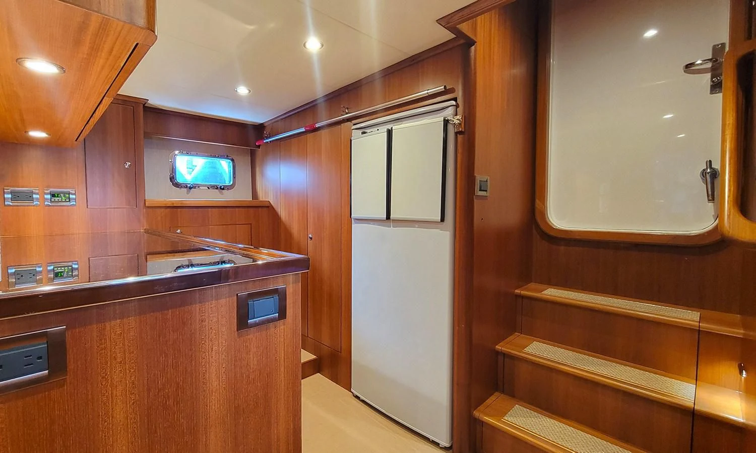 a kitchen with wooden cabinets aboard SUERTUDO Yacht for Sale