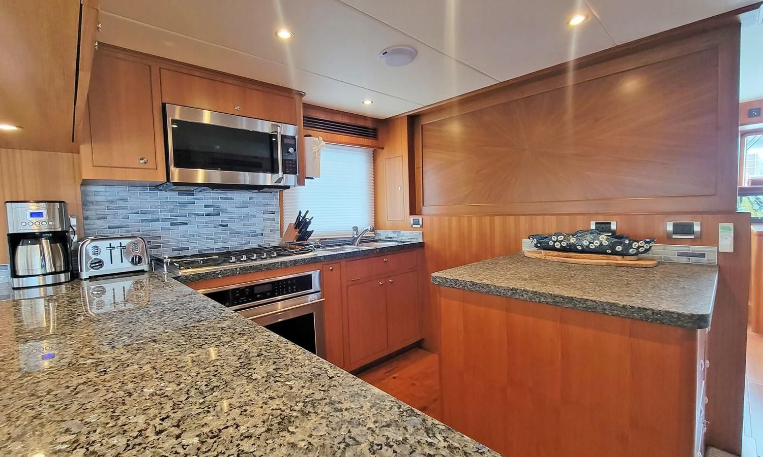 a kitchen with wooden cabinets aboard SUERTUDO Yacht for Sale