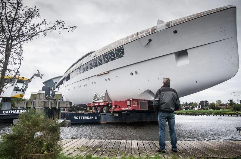 a man standing next to a boat aboard JC Yacht for Sale