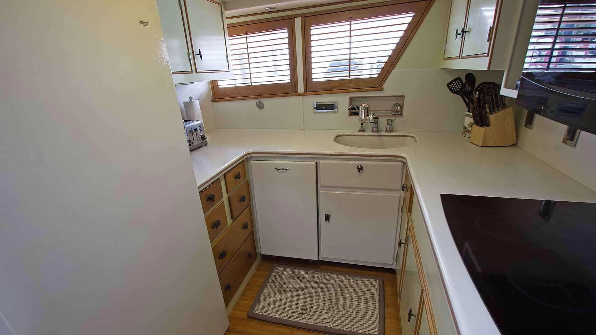 a kitchen with white cabinets aboard KOALA Yacht for Sale