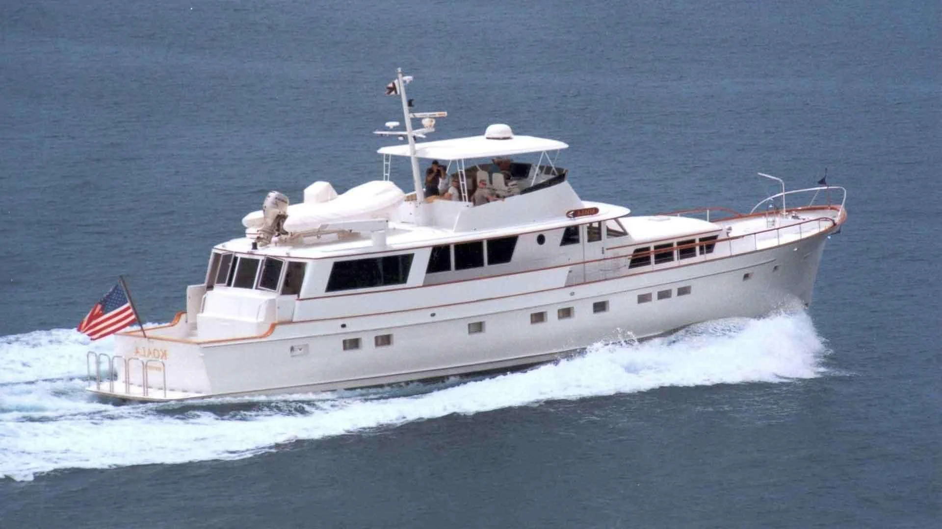 a large white ship with a flag on it aboard KOALA Yacht for Sale