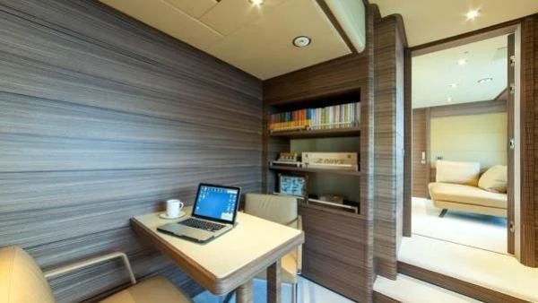 a room with a laptop and a bookcase aboard ORYX Yacht for Sale