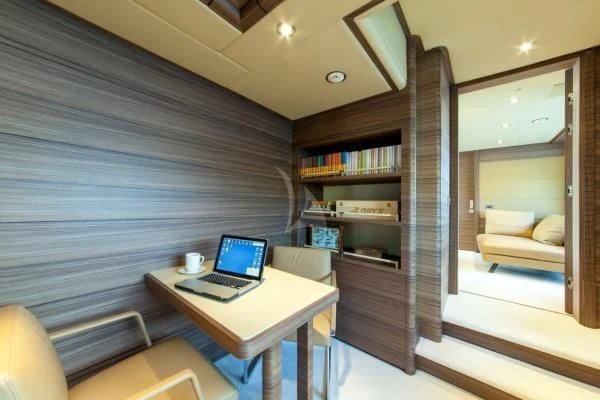 a room with a laptop and a bookcase aboard ORYX Yacht for Sale