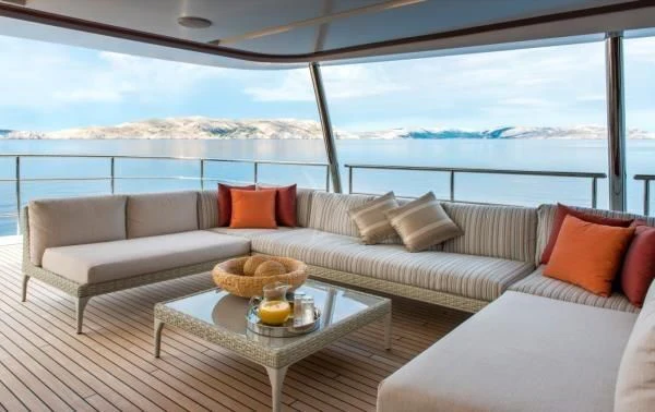 a couch and a table in a room with a view of the ocean aboard ORYX Yacht for Sale