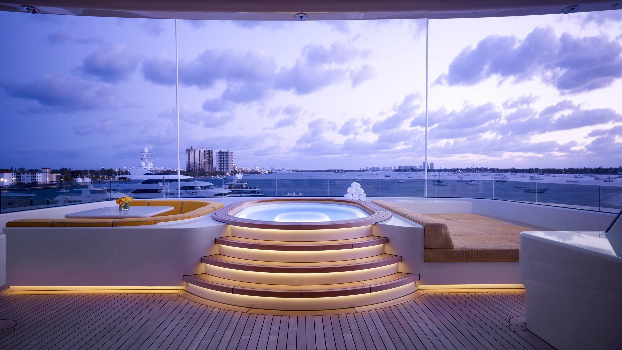 a large white pool with a city in the background aboard AQUARIUS Yacht for Sale