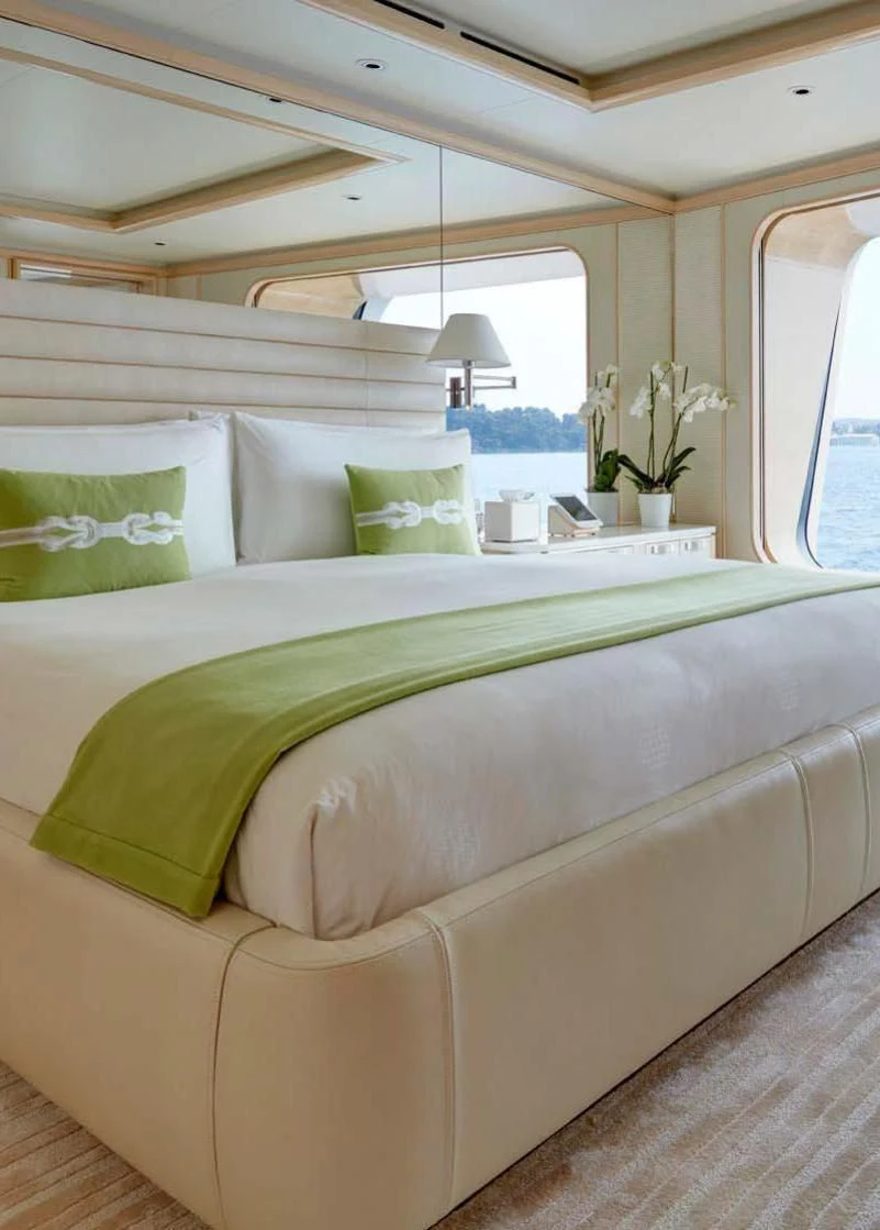 a bed with green sheets aboard AQUARIUS Yacht for Sale