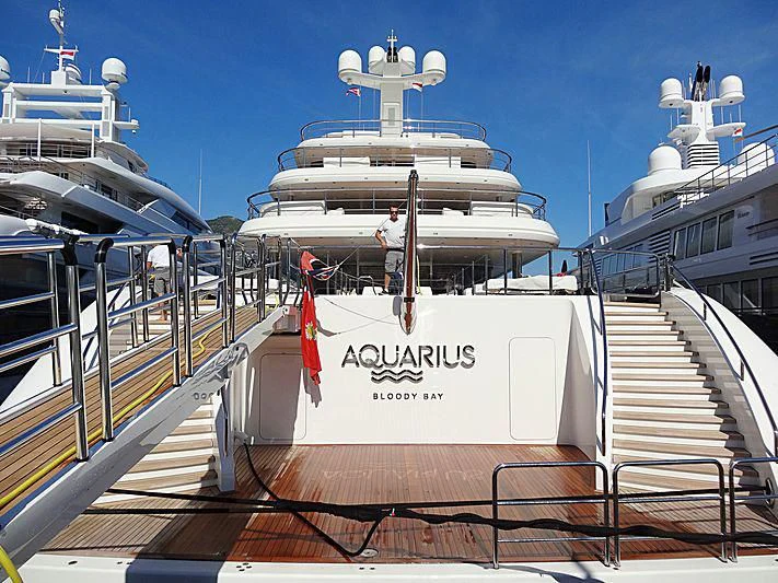 a large white boat with a person standing on the deck aboard AQUARIUS Yacht for Sale