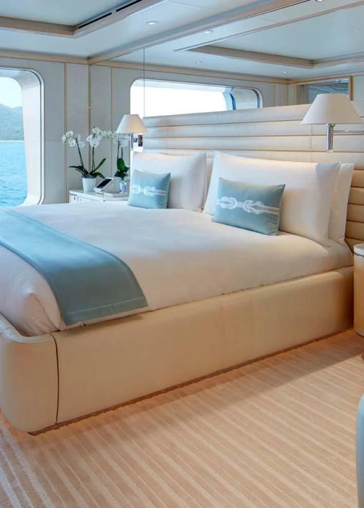 a bed with a white bed spread aboard AQUARIUS Yacht for Sale