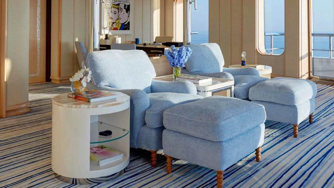 a living room with blue furniture aboard AQUARIUS Yacht for Sale
