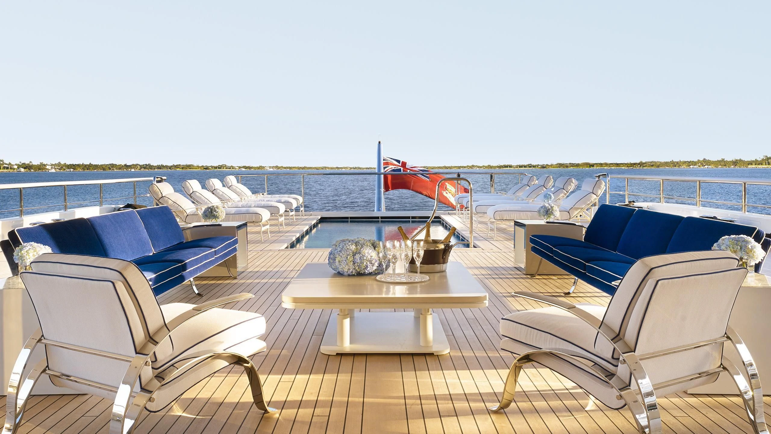 a patio with a table chairs and a fire pit aboard AQUARIUS Yacht for Sale