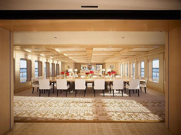 a room with tables and chairs aboard AQUARIUS Yacht for Sale