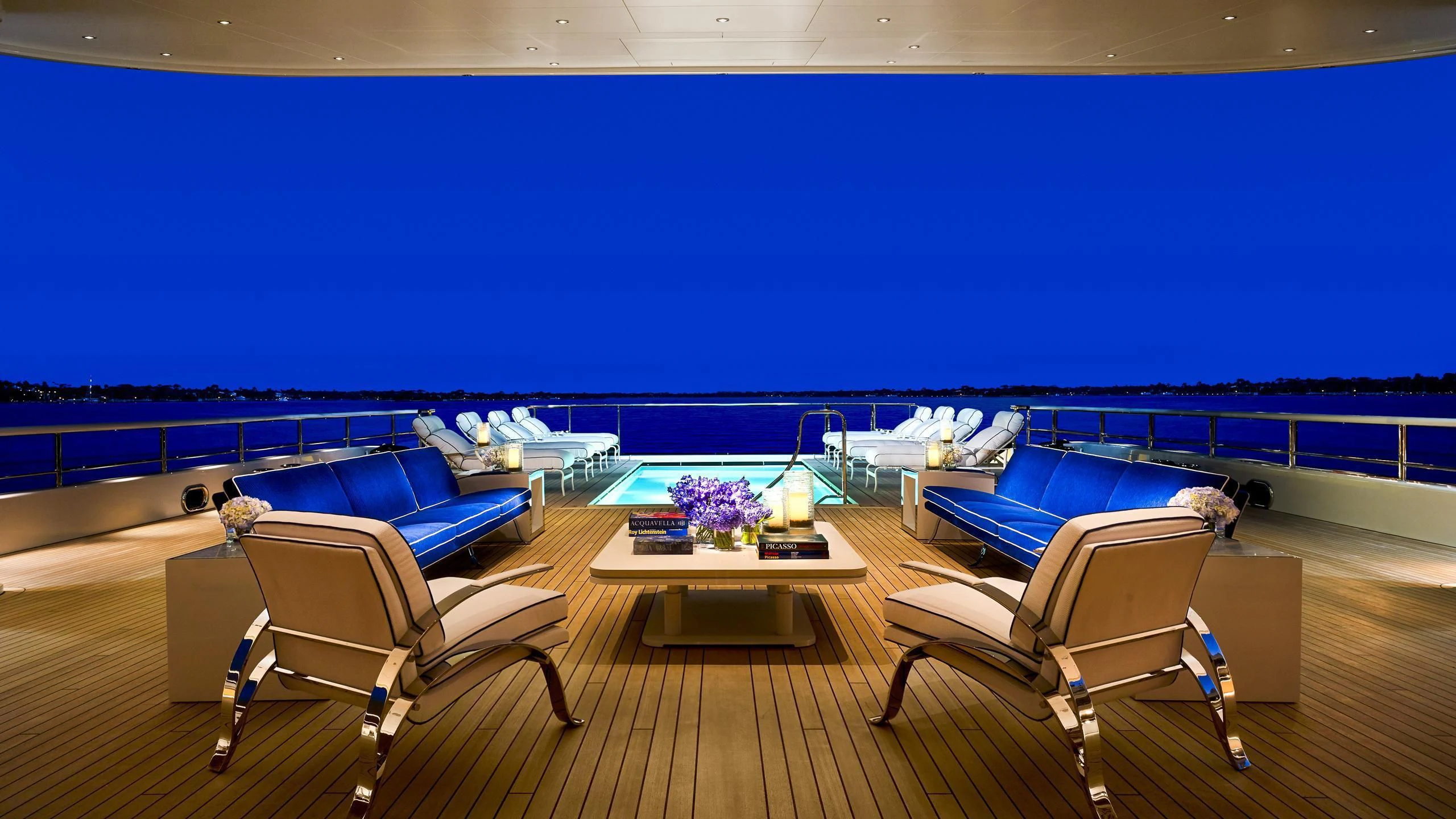 a room with a pool and chairs aboard AQUARIUS Yacht for Sale