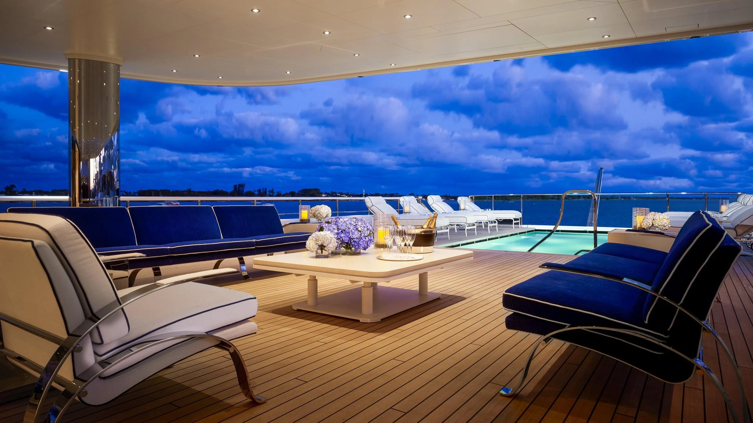 a large room with a deck and chairs and a pool aboard AQUARIUS Yacht for Sale