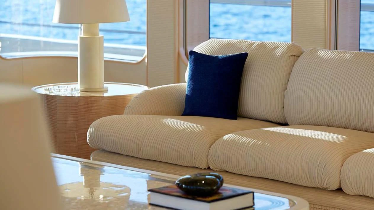 a couch with a remote control aboard AQUARIUS Yacht for Sale