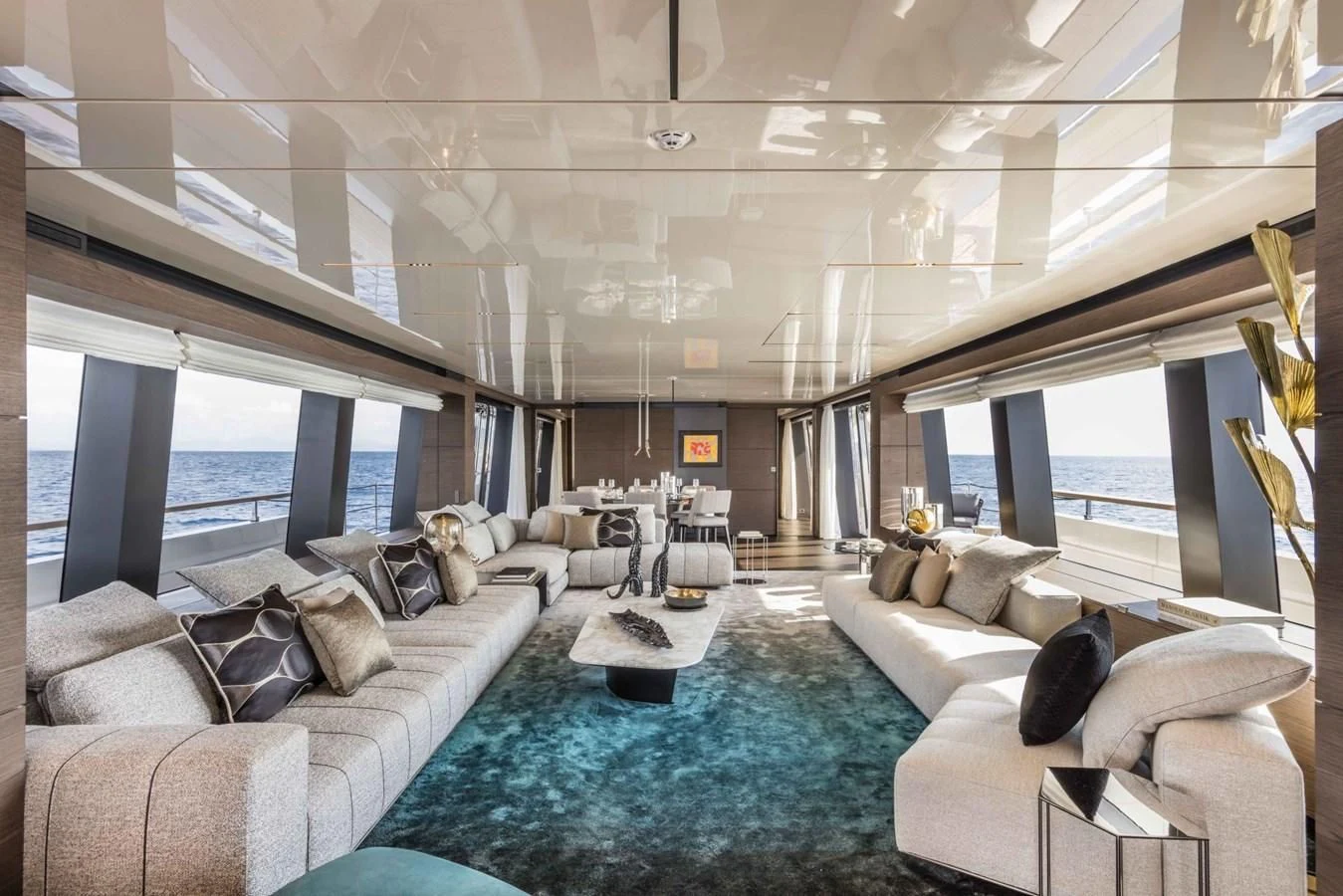 a large room with a large blue rug and white couches aboard NIMIR Yacht for Sale