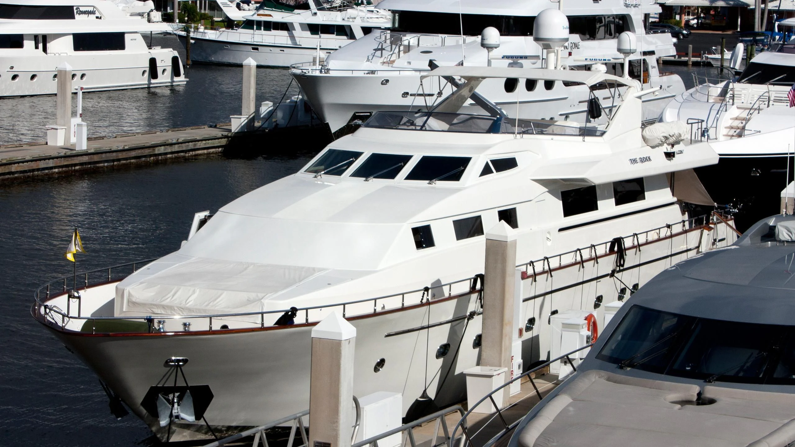 a large white yacht docked aboard THE ROCK Yacht for Sale