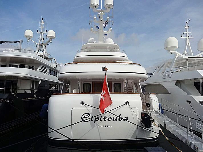 a large white boat with a red flag on it aboard CIPITOUBA Yacht for Sale