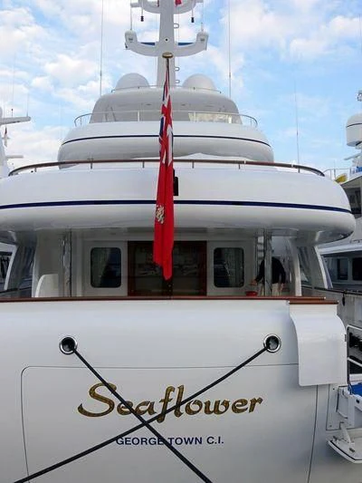 a white yacht with a red ribbon on the front aboard CIPITOUBA Yacht for Sale
