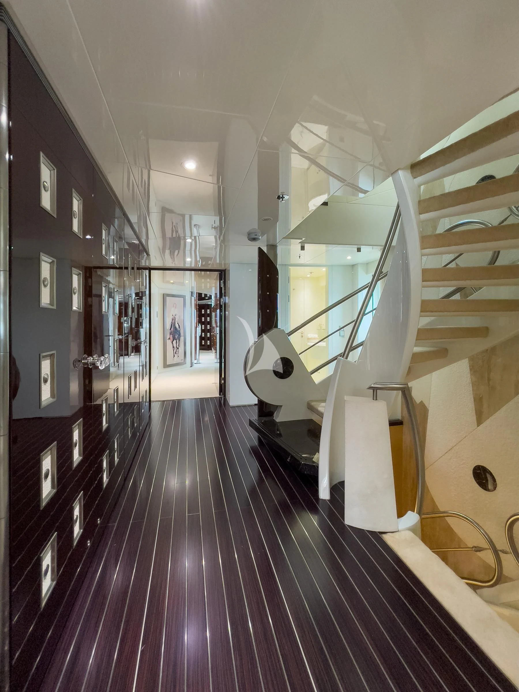 a hallway with a wood floor and white chairs aboard VERA Yacht for Sale