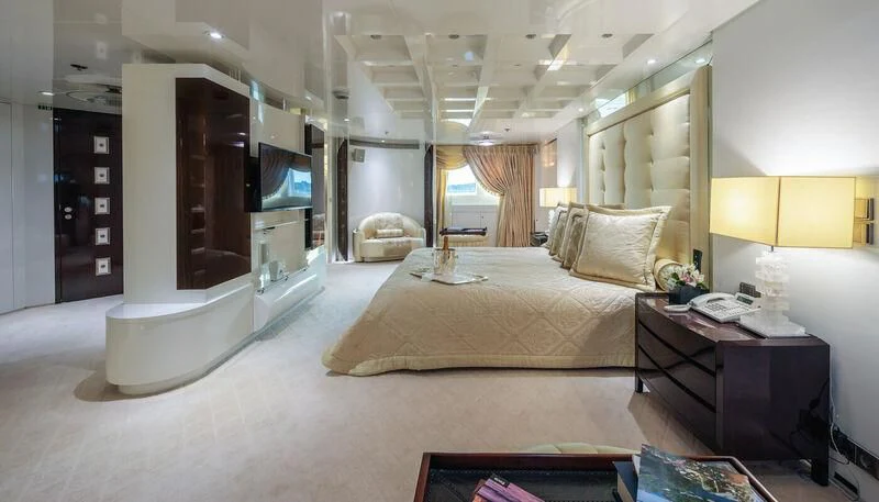 a bedroom with a bed and a desk aboard VERA Yacht for Sale