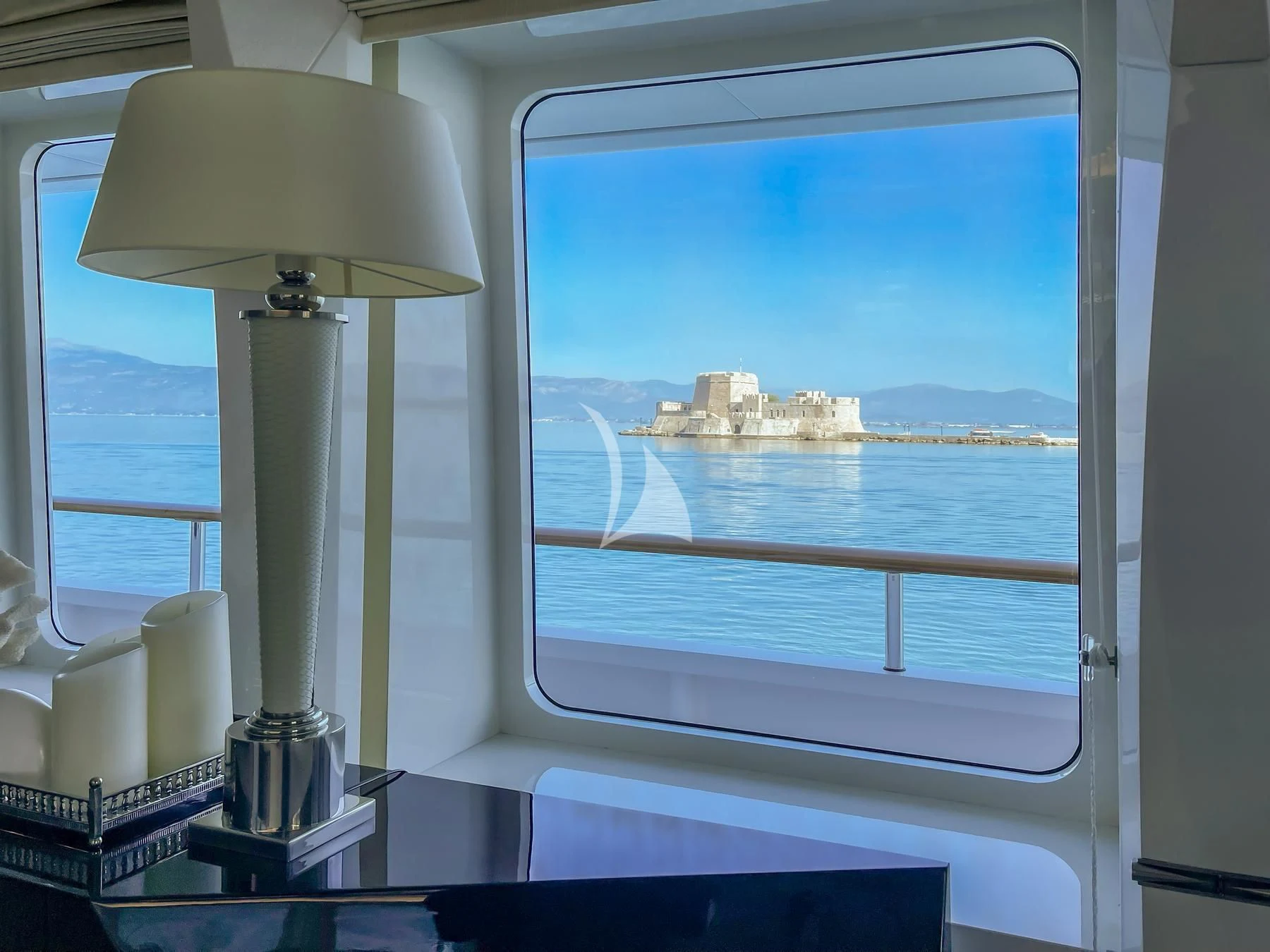 a window with a lamp and a view of the water aboard VERA Yacht for Sale