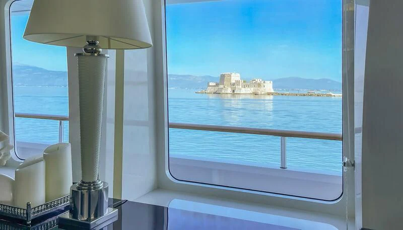 a window with a lamp and a building in the background aboard VERA Yacht for Sale
