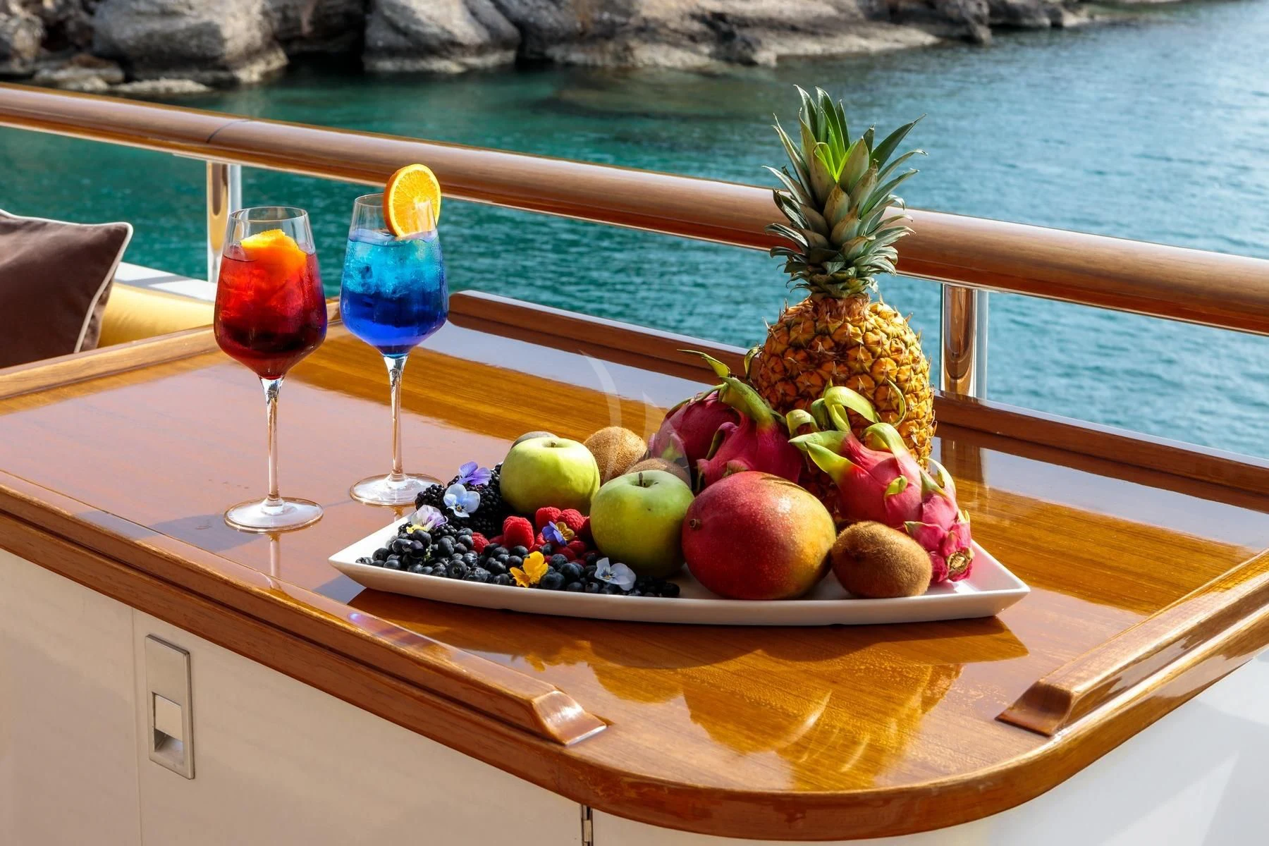 a plate of fruit and wine on a boat aboard VERA Yacht for Sale