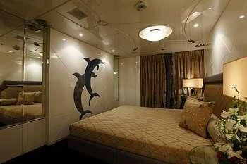 a bedroom with a bed and a large painting on the wall aboard VERA Yacht for Sale