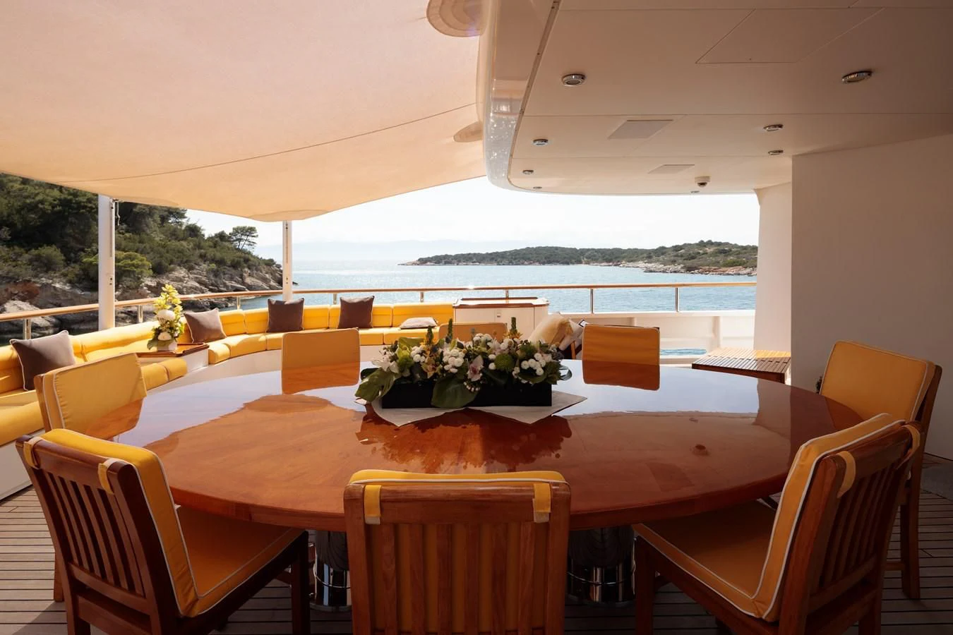 a dining table with chairs and a large window overlooking the ocean aboard VERA Yacht for Sale