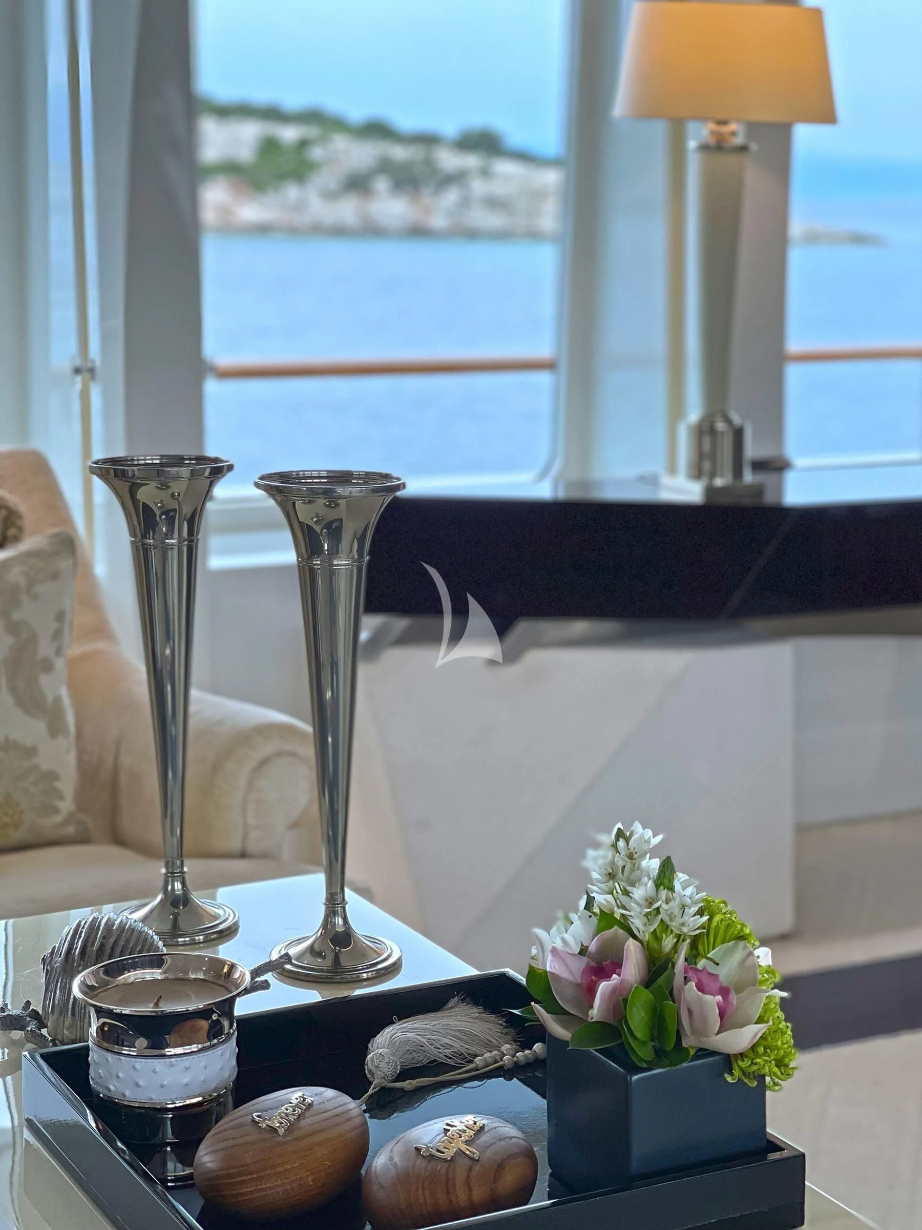 a table with a lamp and a vase with flowers on it aboard VERA Yacht for Sale