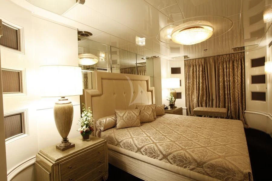a bedroom with a bed and a lamp aboard VERA Yacht for Sale