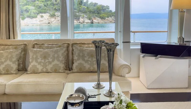 a living room with a glass coffee table and a window aboard VERA Yacht for Sale