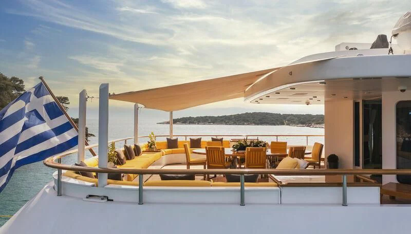 a large lounge area with a large lounge chair and a large umbrella aboard VERA Yacht for Sale