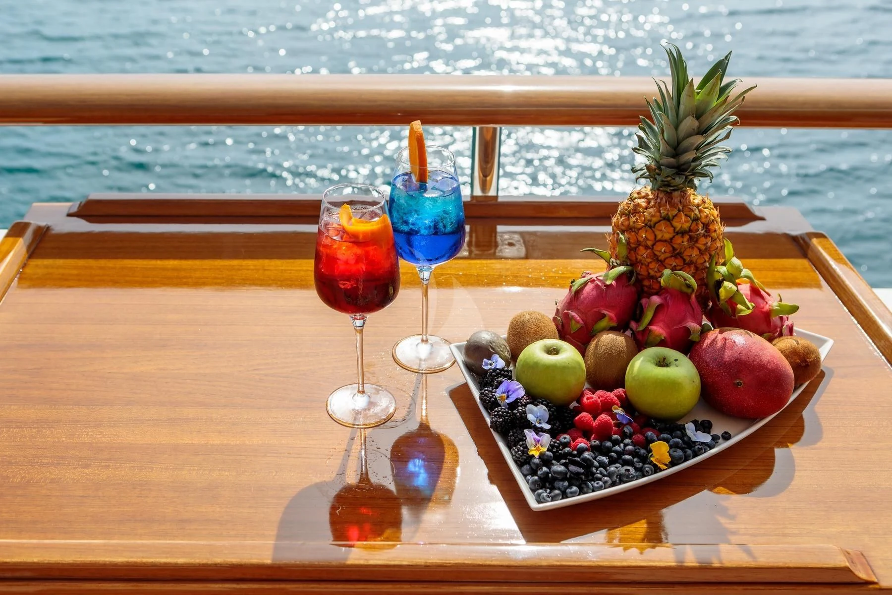 a glass of wine and fruit on a table aboard VERA Yacht for Sale