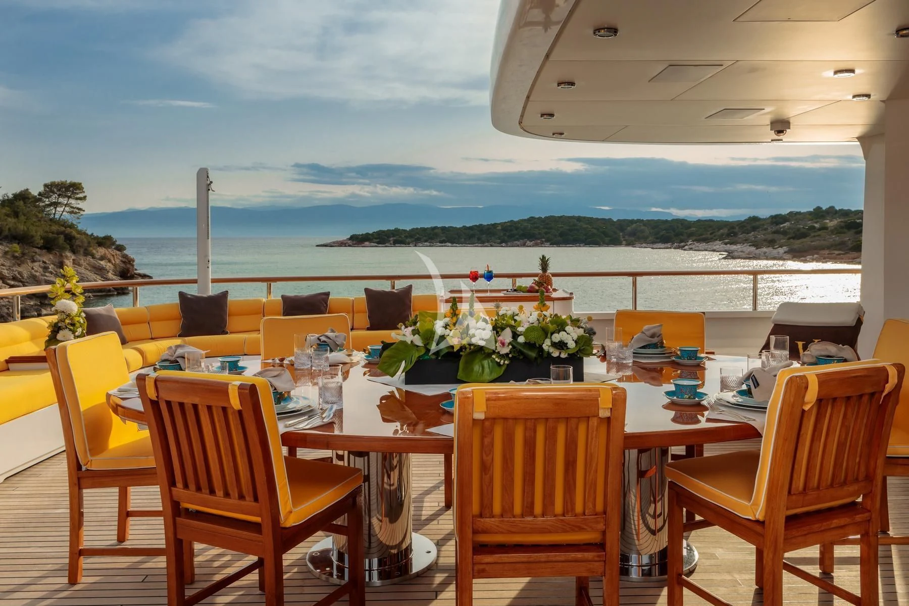 a table and chairs on a deck overlooking a body of water aboard VERA Yacht for Sale