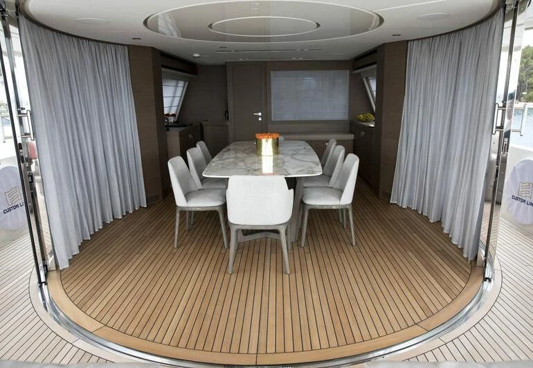 a dining table and chairs in a room with a window aboard CHELONIA Yacht for Sale