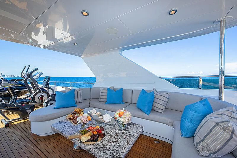 a large white boat with blue pillows and a table with food on it aboard AMORE Yacht for Charter