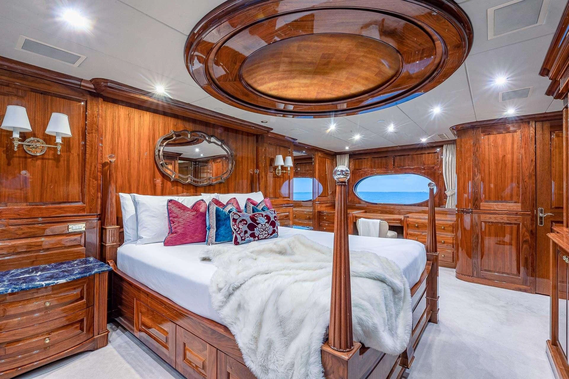a bed with a canopy and a chair in a room aboard AMORE Yacht for Charter