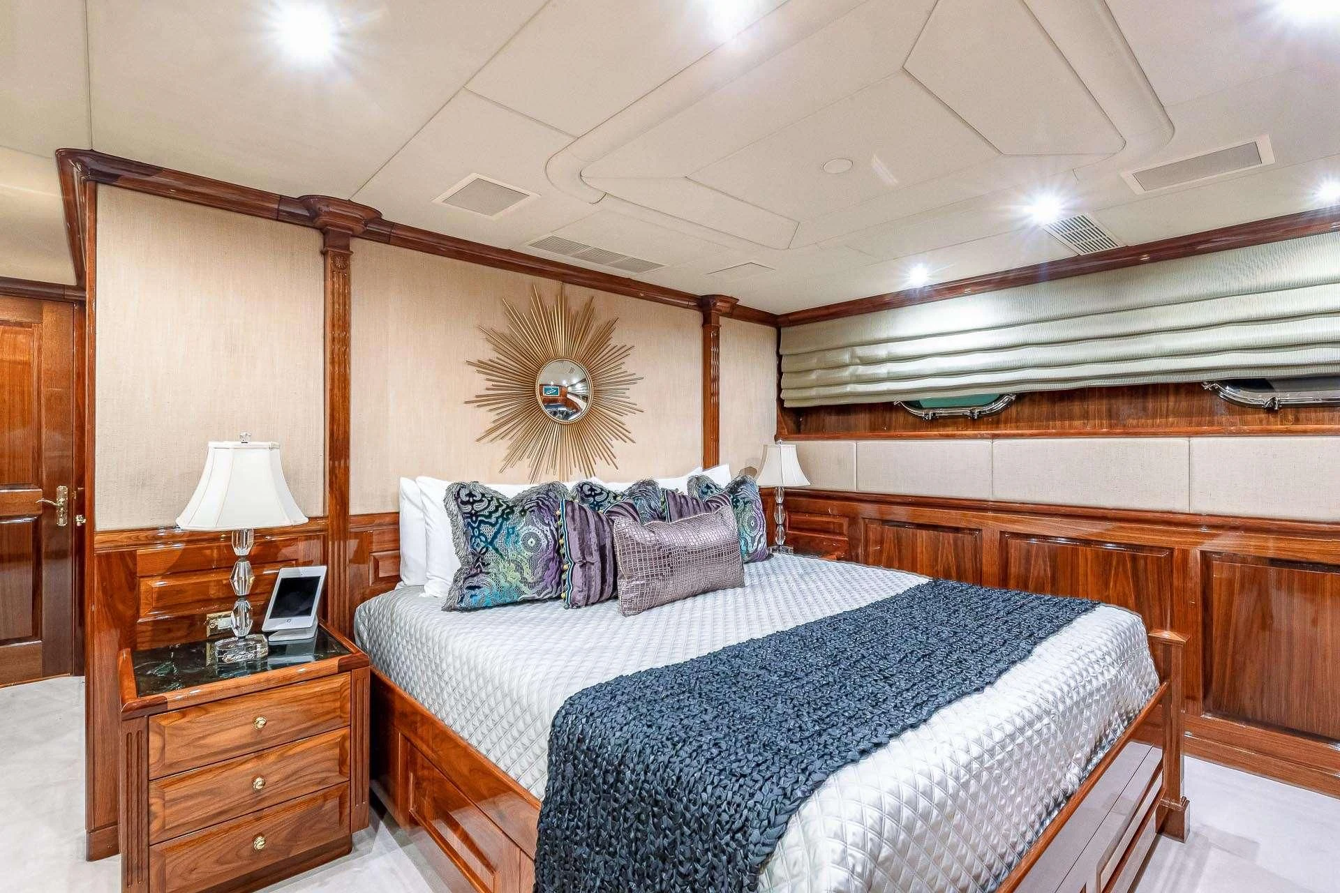 a bedroom with a bed and a dresser aboard AMORE Yacht for Charter