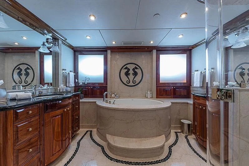 a bathroom with a tub sink and cabinets aboard AMORE Yacht for Charter