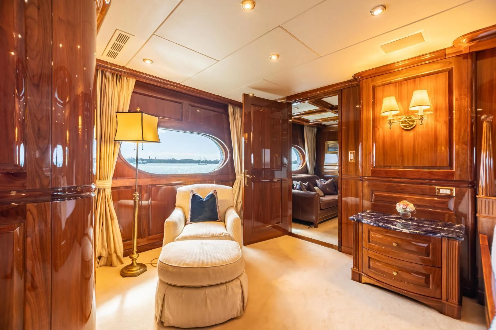a room with a chair and a dresser and a mirror aboard AMORE Yacht for Charter