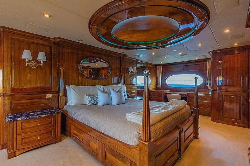 a bedroom with a bed and a chandelier aboard AMORE Yacht for Charter
