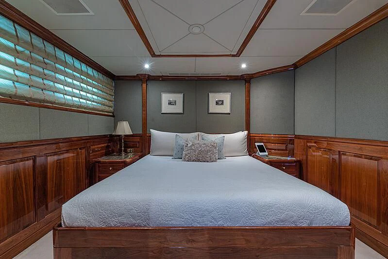 a bed with a wooden headboard aboard AMORE Yacht for Charter