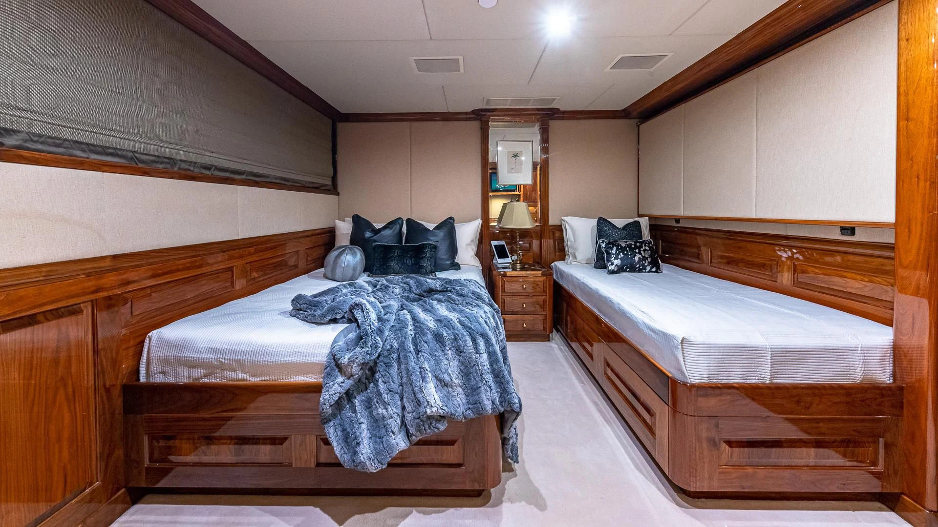 a room with beds and a mirror aboard AMORE Yacht for Charter