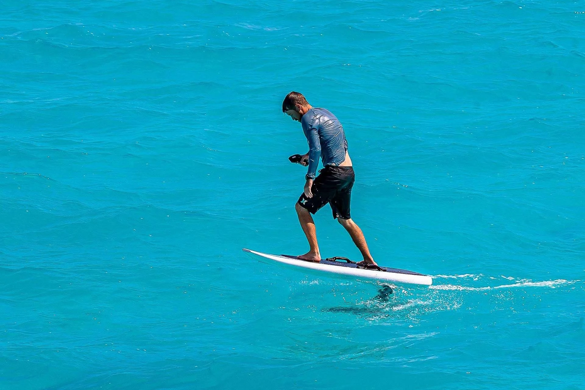 a man is surfing on the water aboard AMORE Yacht for Charter