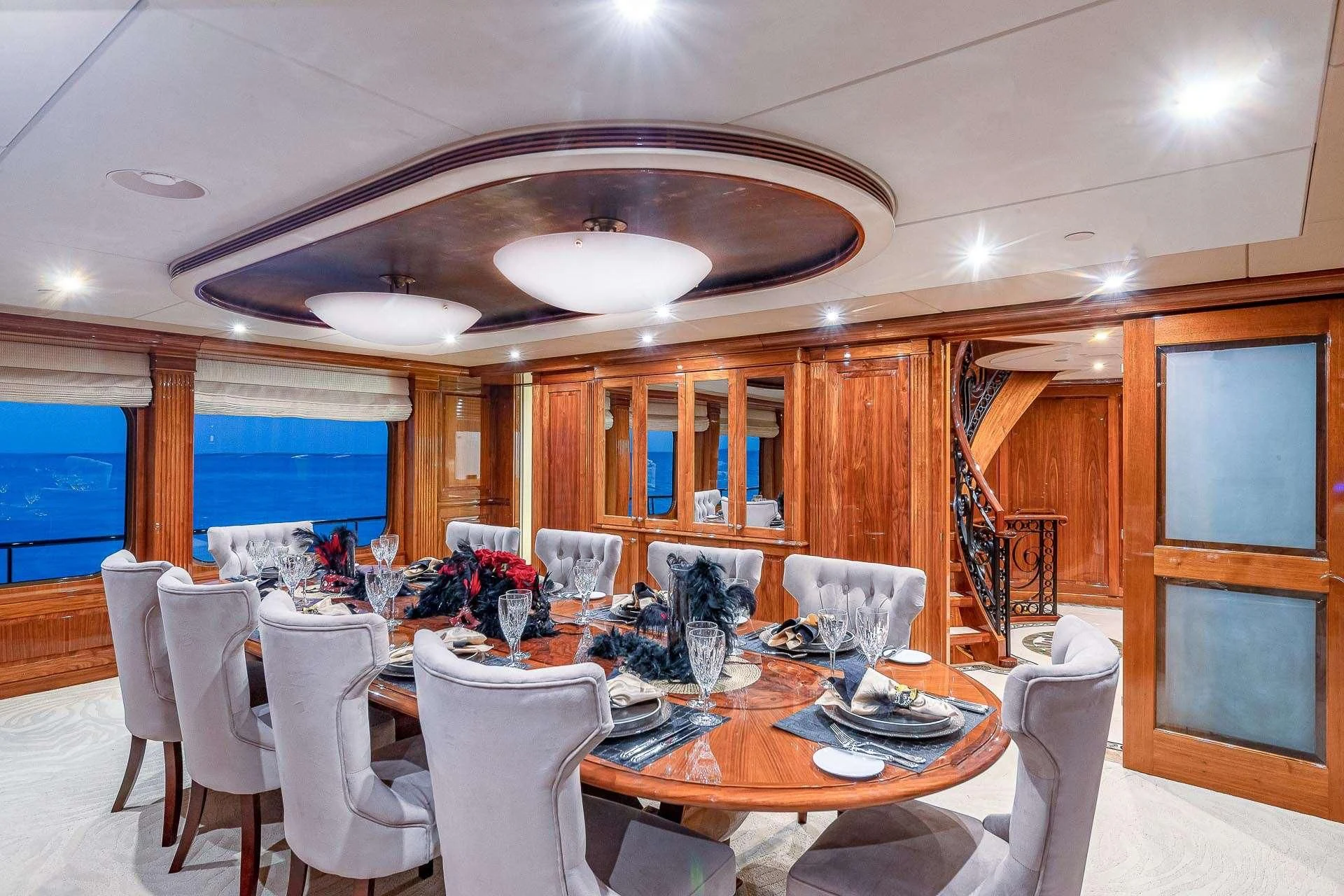 a dining room with a large chandelier aboard AMORE Yacht for Charter